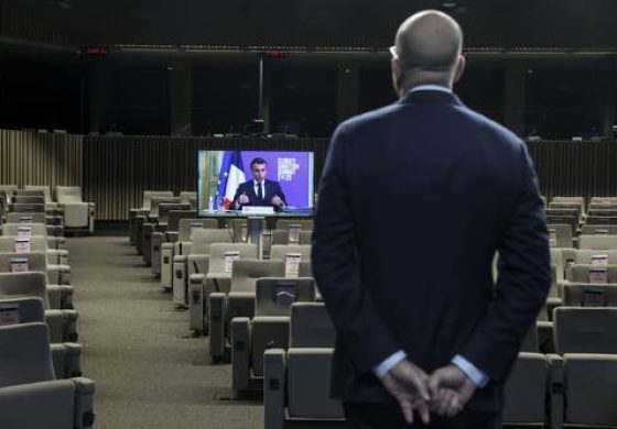 ▲ En primer plano, el presidente del Consejo Europeo, Charles Michel, en Bruselas, y en la pantalla el presidente francés Emmanuel Macron, durante la cumbre climática.